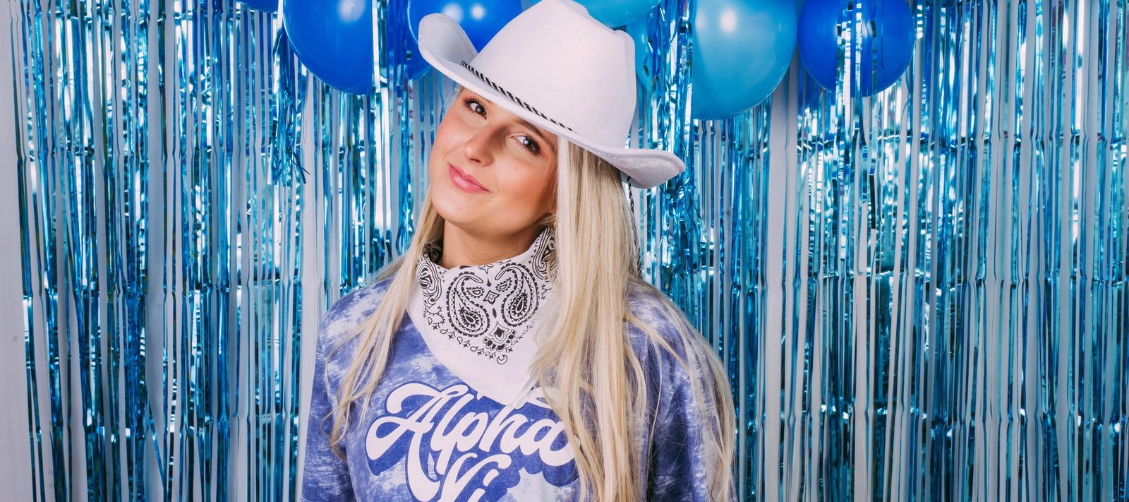 Girl wears a blue Alpha Xi tshirt with a cowboy hat and bandana
