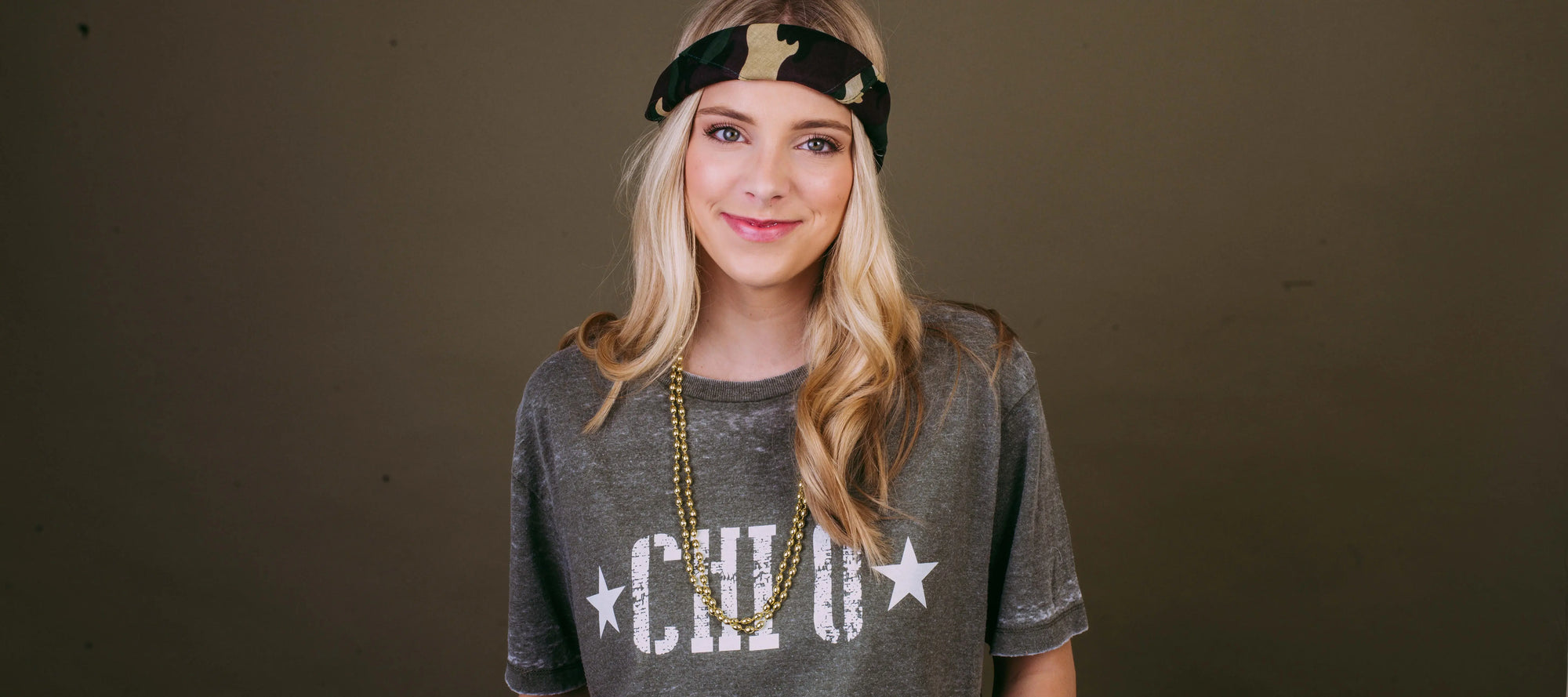 Girl wears a black Chi O tshirt and camo accessories