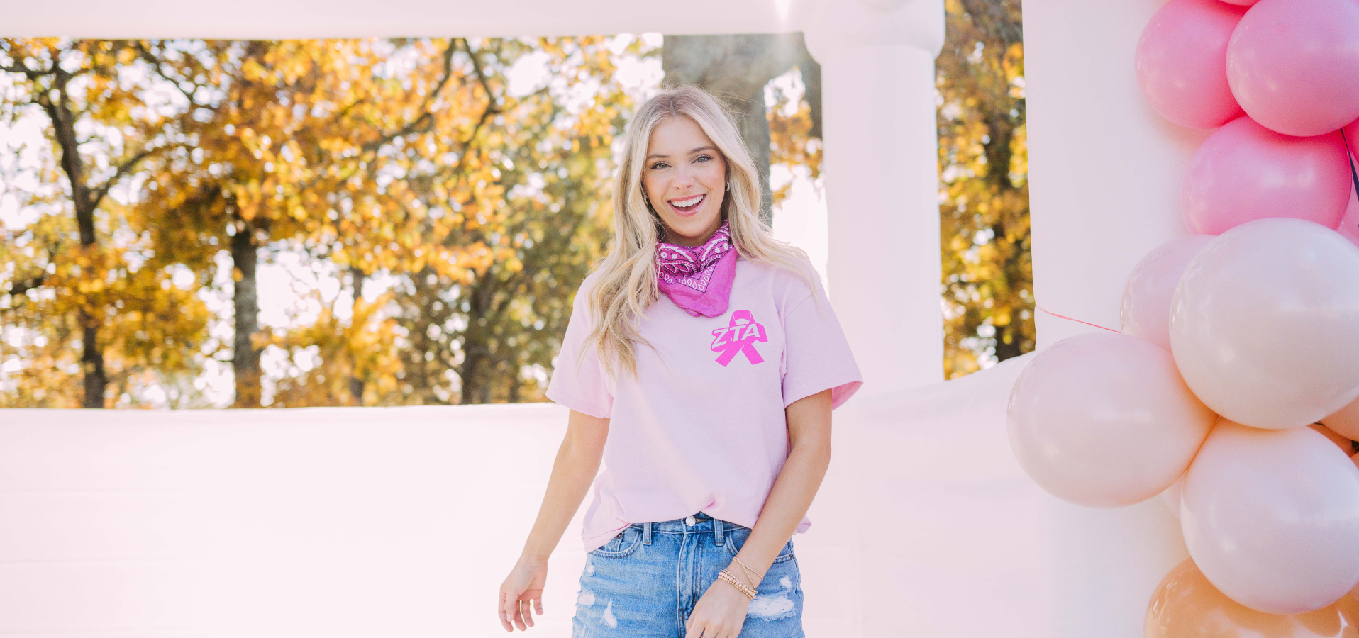 Girl wears a pink tshirt with a ribbon and Zeta letters on the left chest.