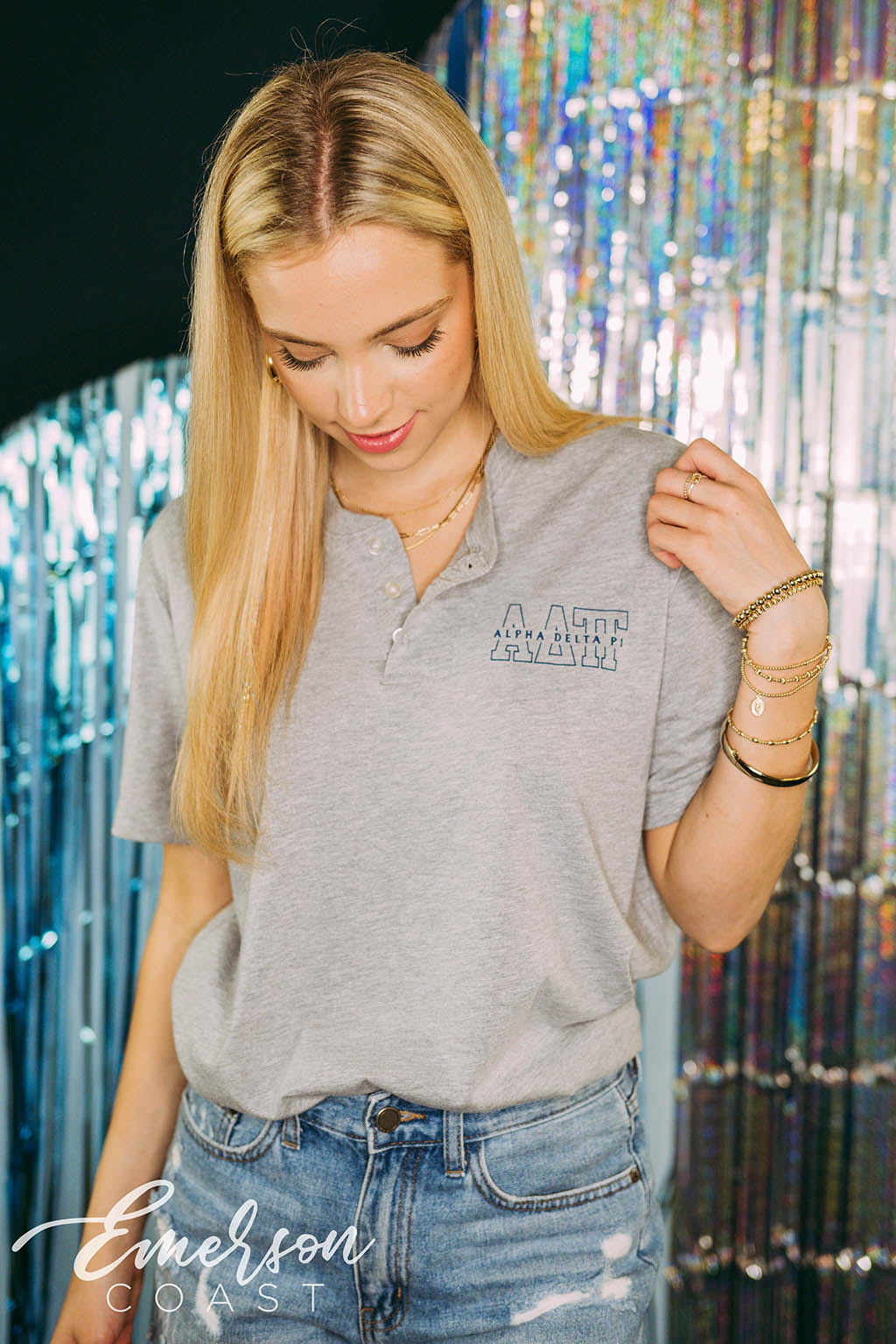 Girl wears light gray henley with ADPi letters on left chest.