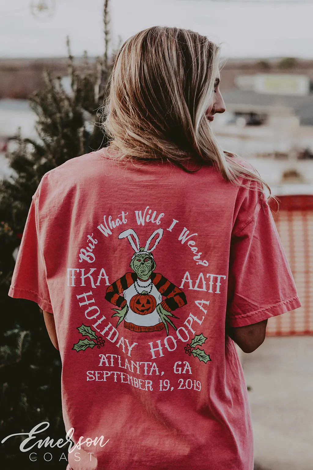 Girl wears a red tshirt with Pi Kappa Alpha and ADPi letters on it featuring a picture of the Grinch in various holiday attire.