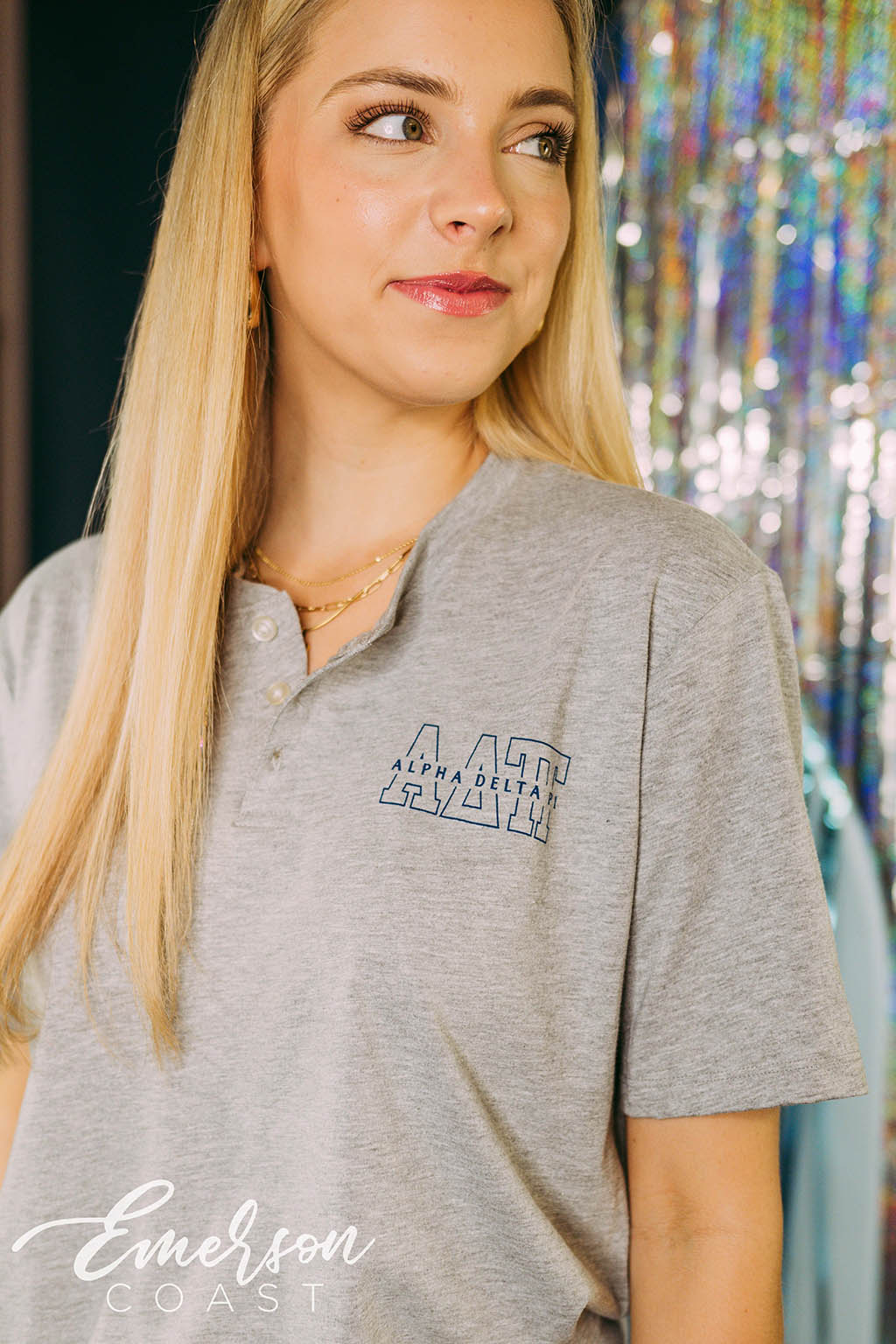 Girl wears light gray henley with ADPi letters on left chest.