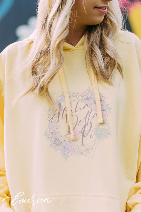Girl wears a yellow hoodie that reads Alpha Delta Pi.