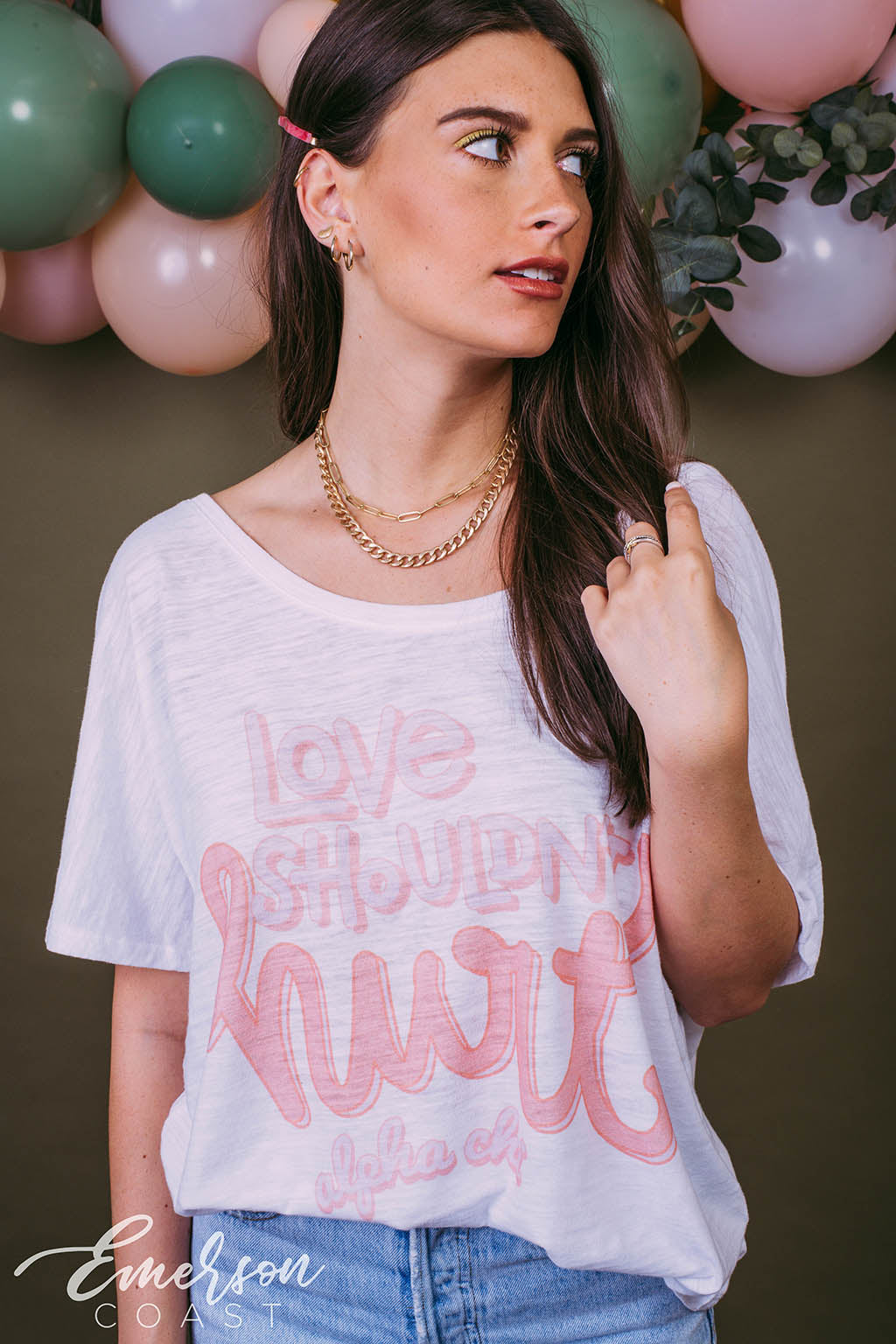 Girl wears white "Love Shouldn't Hurt" Alpha Chi shirt