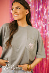 Girl wears green shirt with ADPi letters on front left pocket.