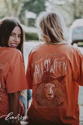 Girl wears orange ADPi Halloween Tshirt featuring a picture of a lion wearing a witch hat.