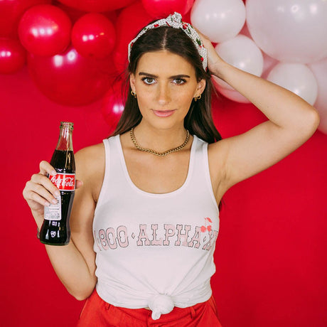 Girl wears white tank with 1-800-Alpha-Xi written across it.