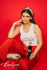 Girl wears white tank with 1-800-Alpha-Xi written across it.