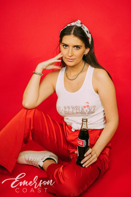 Girl wears white tank with 1-800-Alpha-Xi written across it.